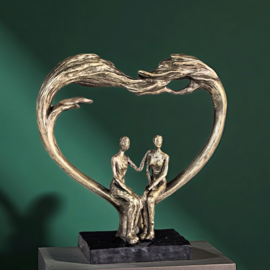 Арт скулптура с бронзов ефект, изобразяваща голямо сърце, образуващо арка над седяща двойка