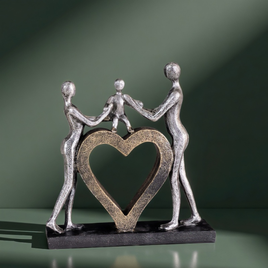 Сребриста статуетка на родители, държащи дете за ръце, стъпило върху златно сърце