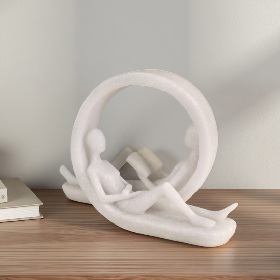 Бяла абстрактна статуетка от полирезин с ефект на бял камък, изобразяваща двойка, лежаща в кръг и четяща книга