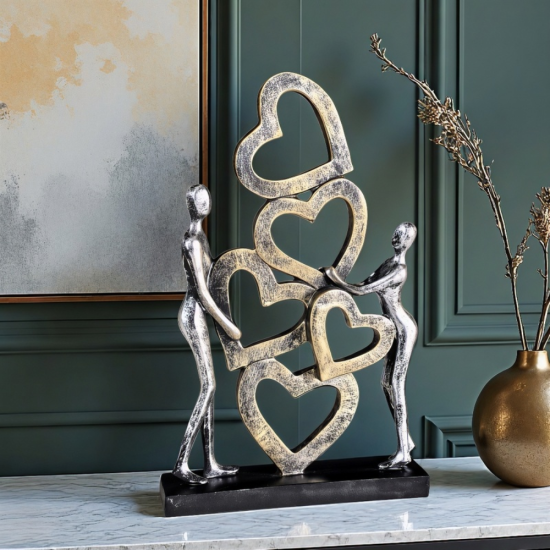 Вертикална статуетка на мъж и жена, държащи вертикална композиция от преплетени сърца