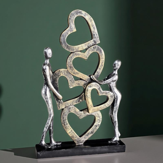 Вертикална статуетка на мъж и жена, държащи вертикална композиция от преплетени сърца