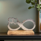 Сребриста метална статуетка във формата на знак за безкрайност, преливащ в две сърца