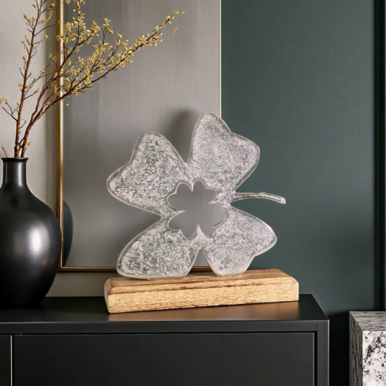 Сребриста метална статуетка във формата на четирилистна детелина с централен отвор