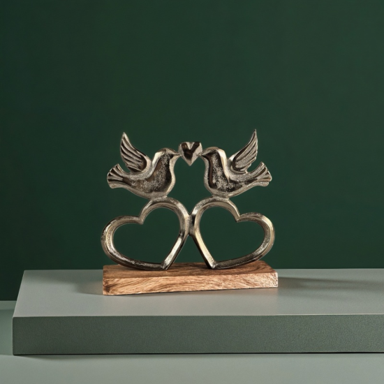 Метална статуетка на два влюбени гълъба, кацнали върху преплетени сърца, разположени на дървена основа